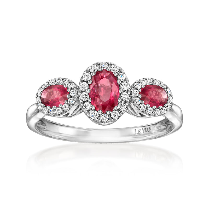 Halo ruby cluster ring with three round pink-red gemstones and diamond accents, gold band