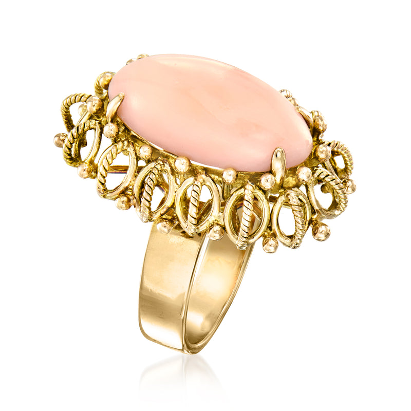 Oval coral-pink gemstone ring with gold bead-and-knot detail and 14kt yellow gold band