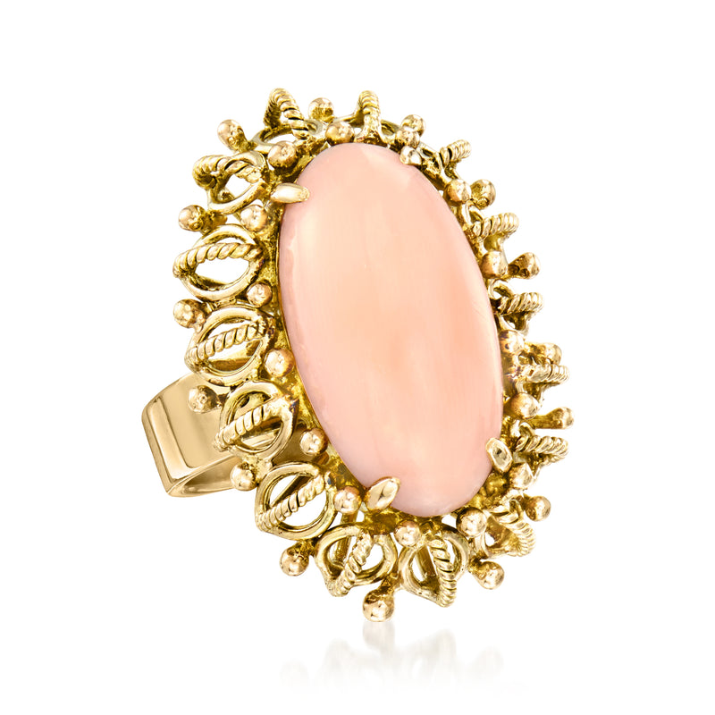 Oval coral-pink gemstone ring with textured gold fringe filigree and 14kt yellow gold