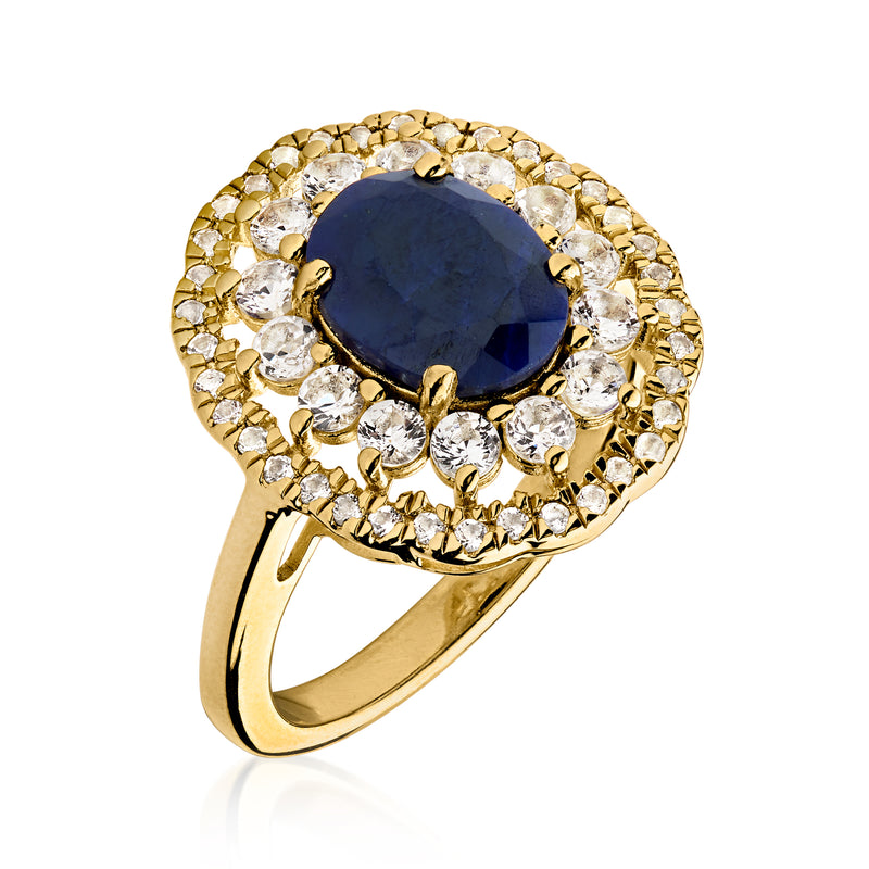 Gold ring side view with oval blue sapphire center and white topaz halo