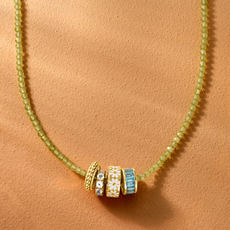 Peridot bead necklace close-up with gold spacer charm and blue accents
