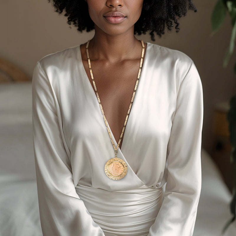 Gold coin pendant necklace worn with dainty chain and round medallion on neckline