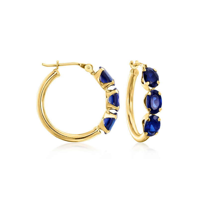 Yellow gold hoop earrings with three blue sapphire-style stones on each hoop