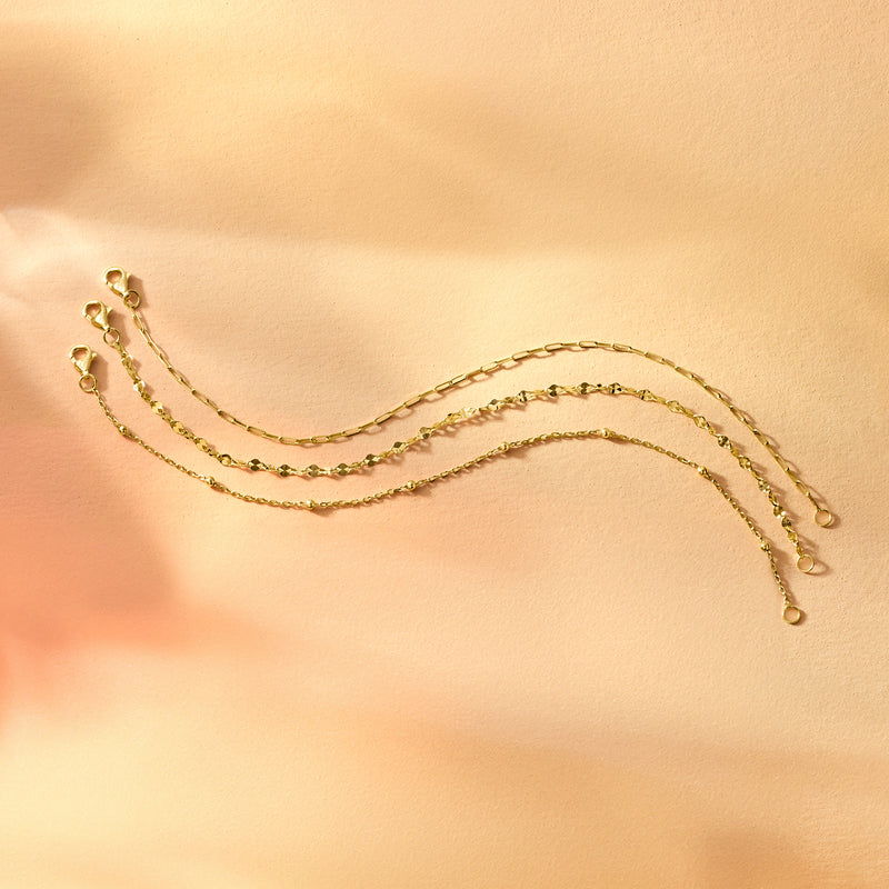 Gold-tone chain bracelets with small clasp ends, laid flat for display