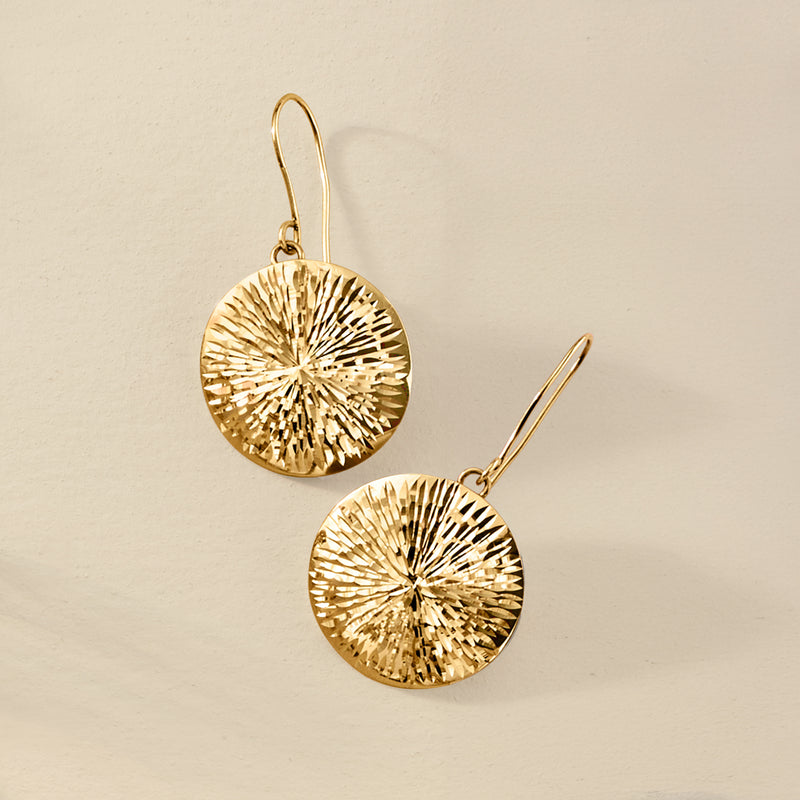 Gold sunburst medallion drop earrings with circular textured medallions on earwire