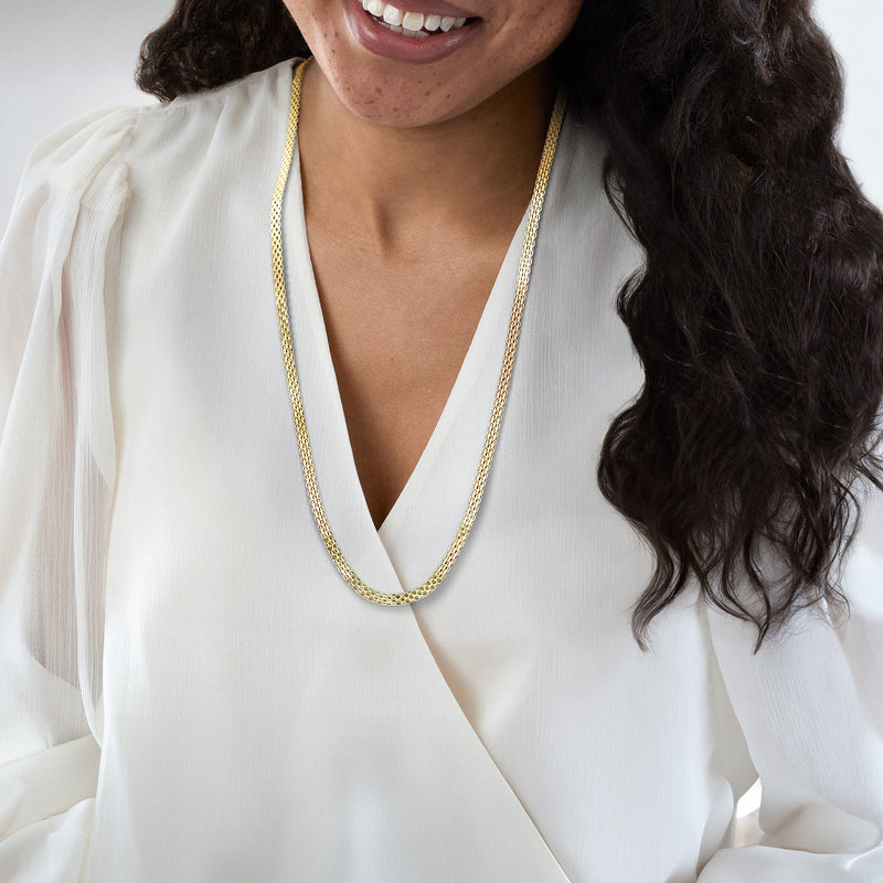 Yellow gold mesh necklace worn on neckline with V-shaped drop