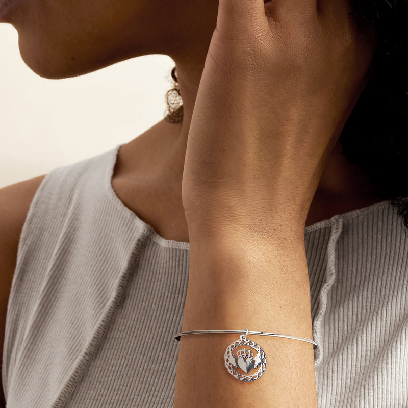 Sterling silver claddagh bangle bracelet with round heart charm on wrist