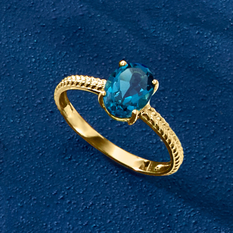 Blue topaz oval center on twisted yellow gold ring, shown at an angle