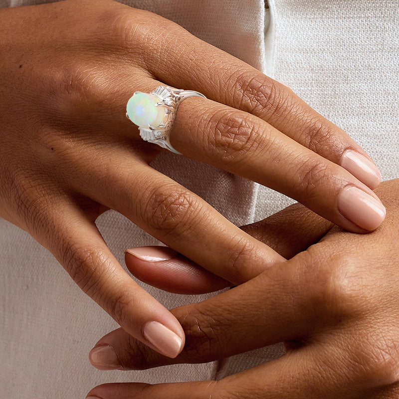 Diamond and opal vintage ring on hand, oval opal with sparkle halo setting