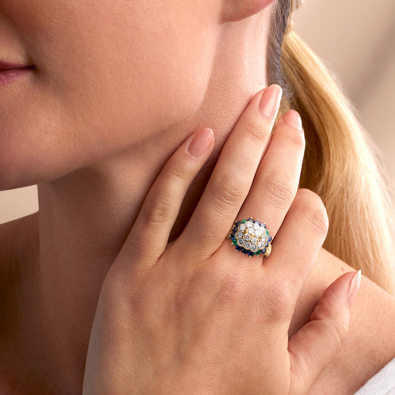 Yellow gold cluster ring with diamonds, blue sapphires, and green emeralds