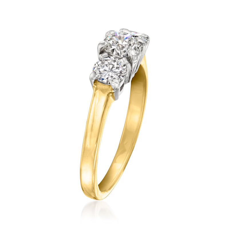 Angled view of three-stone diamond ring: platinum setting on yellow gold band