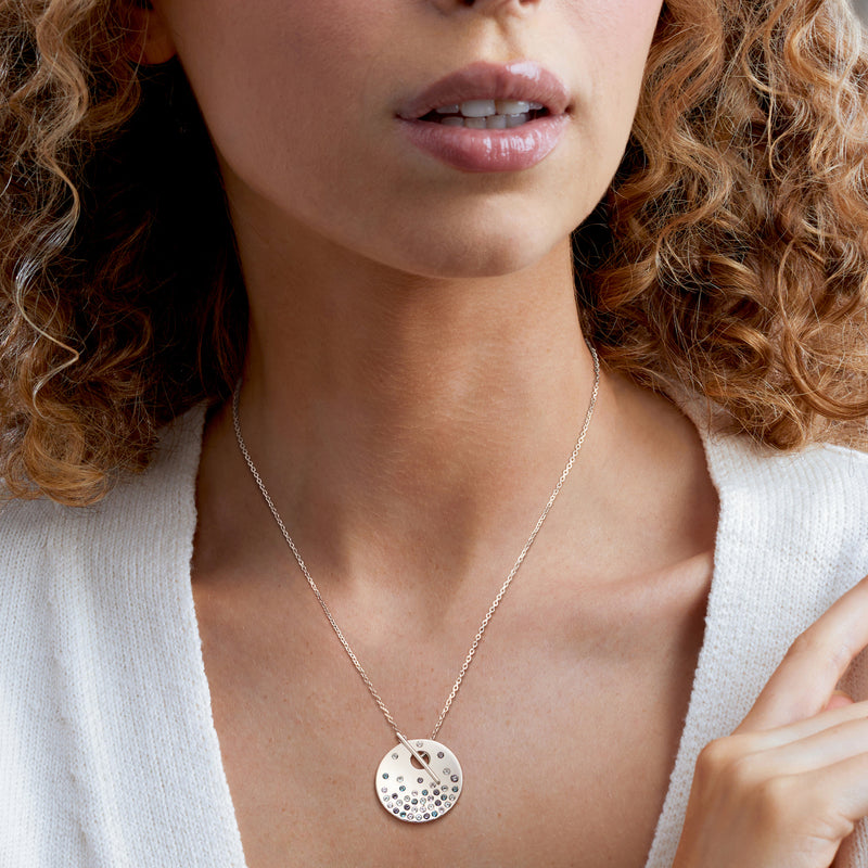 Sterling silver chain necklace with round toggle pendant and blue gemstone sparkle