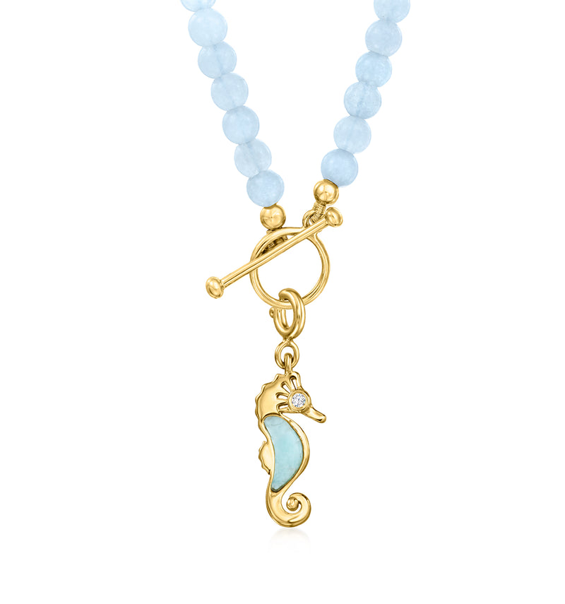 Seahorse charm pendant with white topaz in gold setting on blue beads