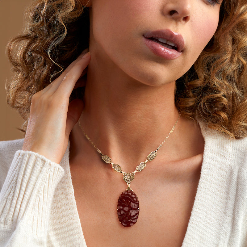 14kt yellow gold necklace with red carved carnelian pendant, worn on neckline
