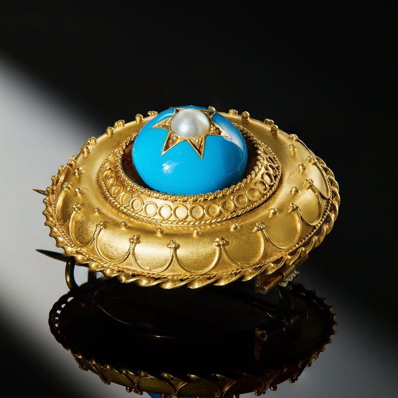Ornate round yellow gold-tone pin with blue resin disc, star and white pearl