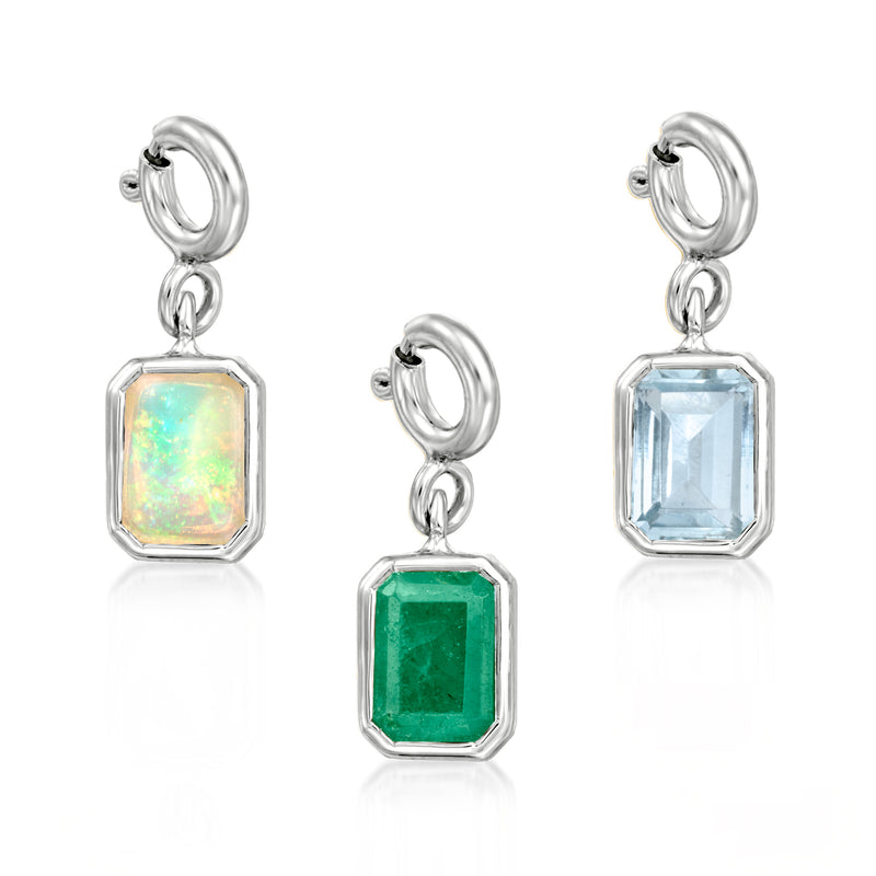 Sterling silver birthstone charm set with emerald-cut stones in green, blue, and opal
