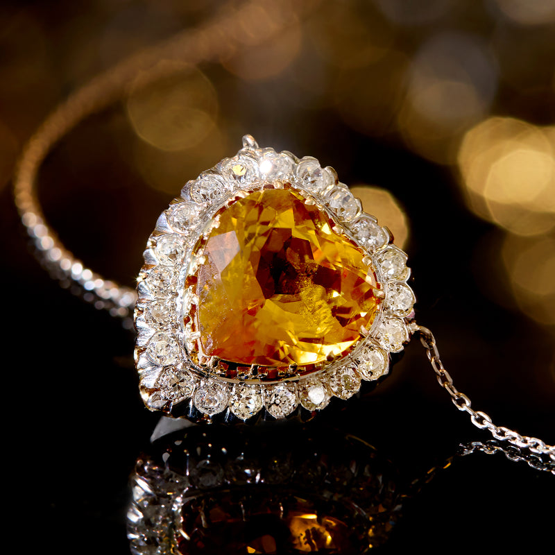 Heart citrine gemstone pendant with diamond halo, shown on a chain