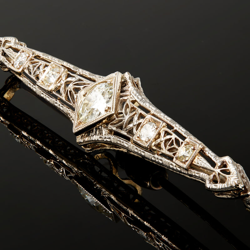 Close-up diamond filigree bar pin with prong-set stones and angled settings