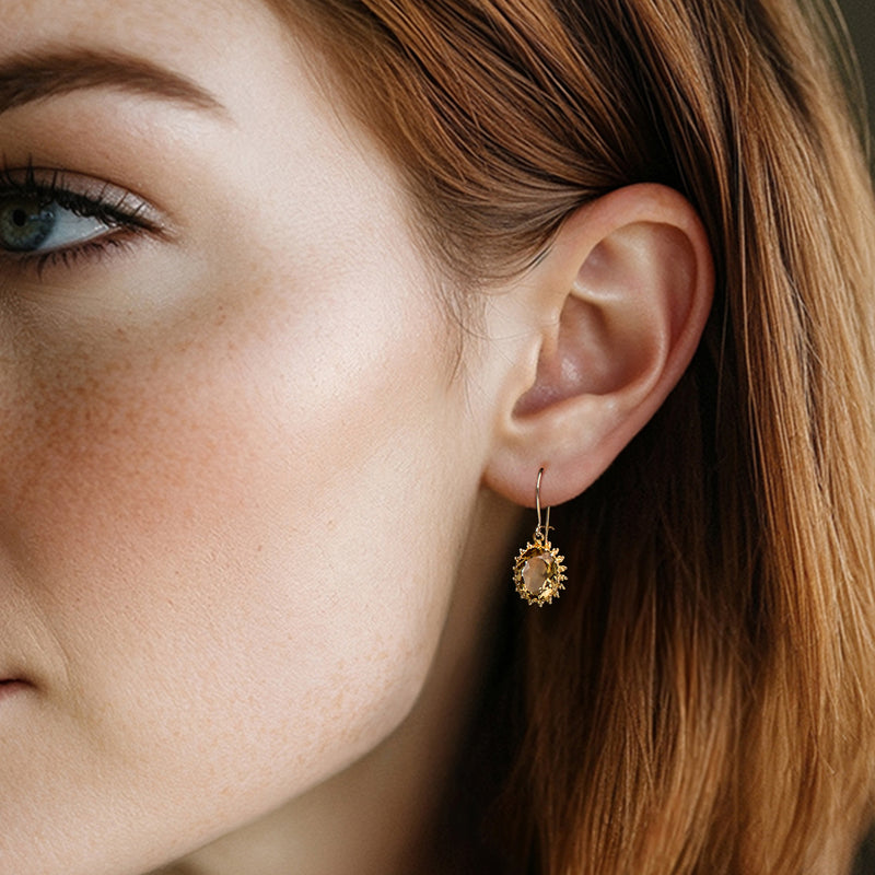 Citrine halo drop earrings in yellow gold on ear with hook earwire