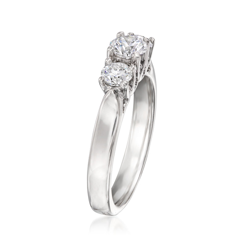 Three-stone diamond ring angled side view, prong-set center diamond with two side stones