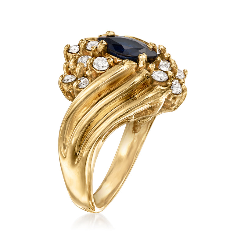 14kt yellow gold swirl ring with oval dark blue sapphire, surrounded by round diamonds
