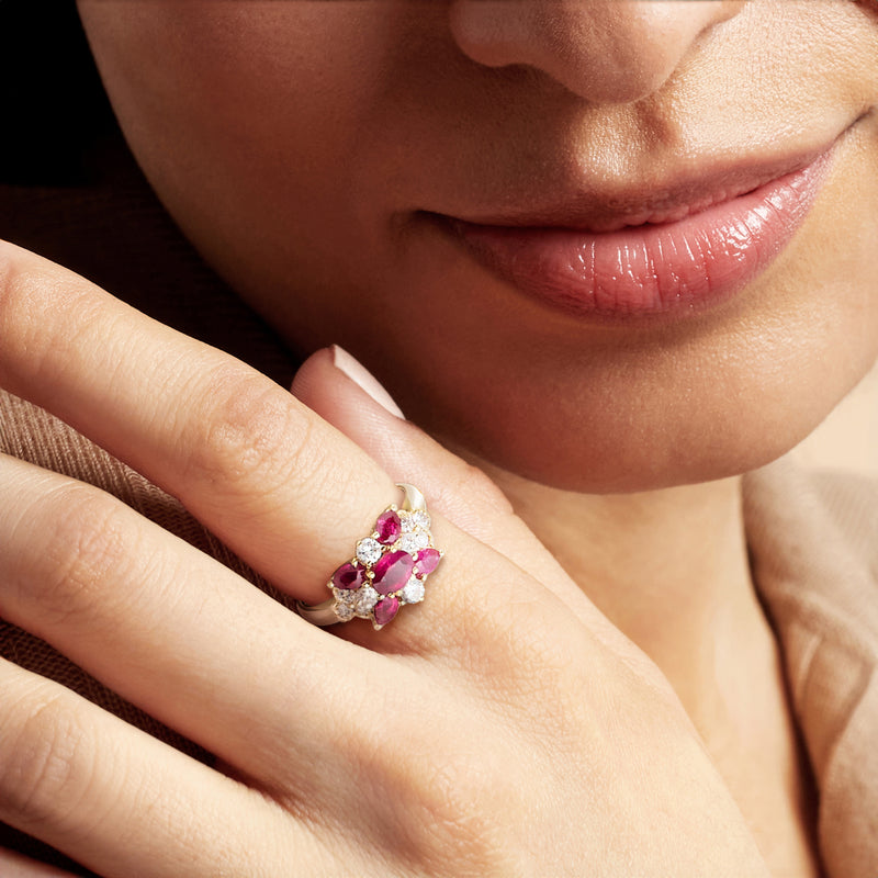 18kt yellow gold ruby and diamond ring on model hand with oval center and round stones