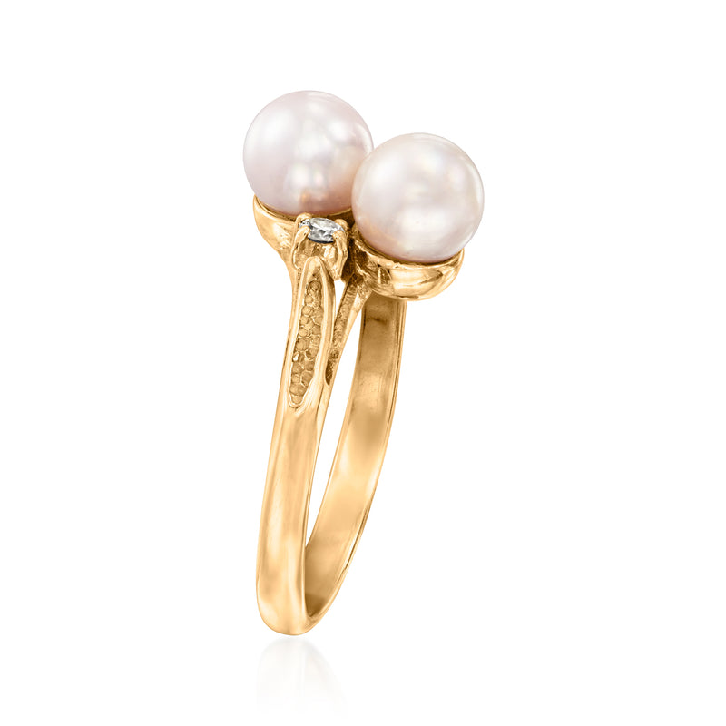 Yellow gold bypass ring with two white cultured pearls and small side diamond settings.