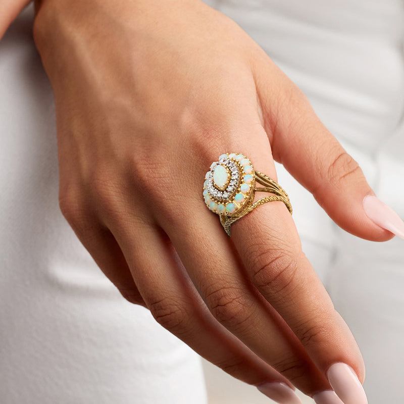 Opal and diamond ring in 18k yellow gold on hand, oval opal center with halo