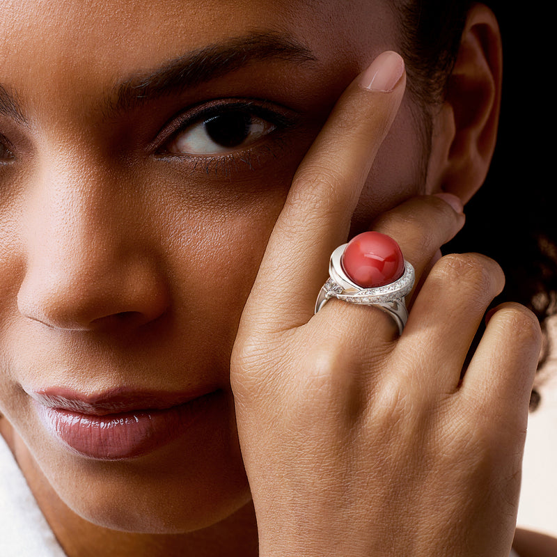 Platinum coral cabochon diamond ring on hand, close-up view