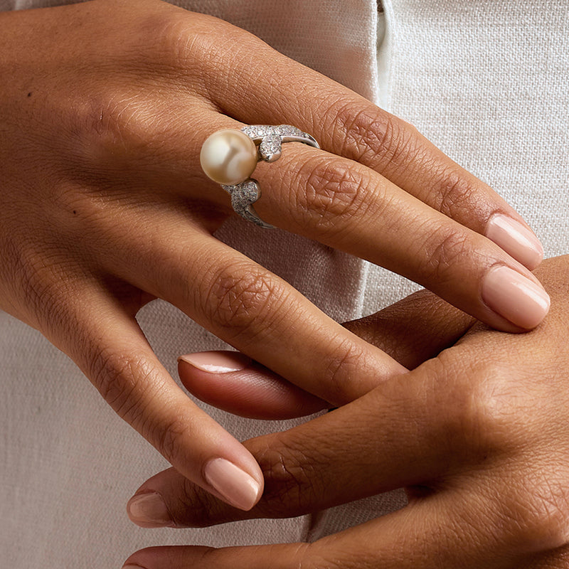 Cultured pearl ring on hand, large cream pearl with diamond accents in white gold