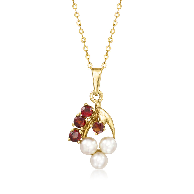 Yellow gold pendant necklace with floral cluster, red stones, and three white pearls