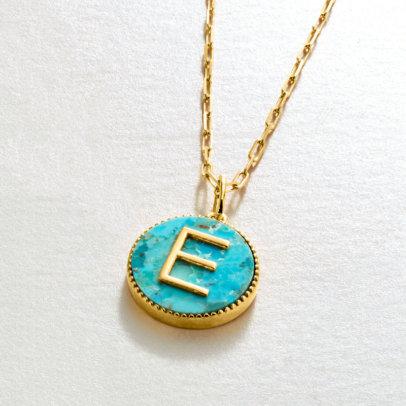 Turquoise initial pendant necklace with gold-tone circular pendant and letter E