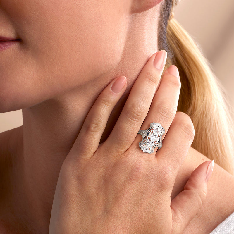 Diamond and blue sapphire vintage ring on hand, ornate white gold setting