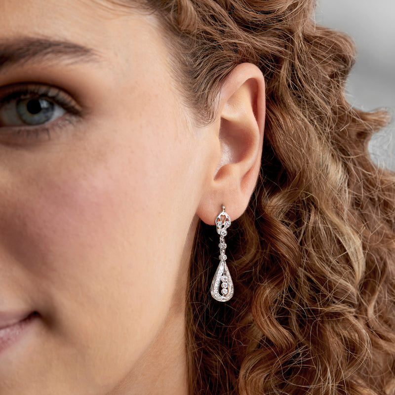 Two-tone gold diamond teardrop drop earrings worn, with long dangling dangles