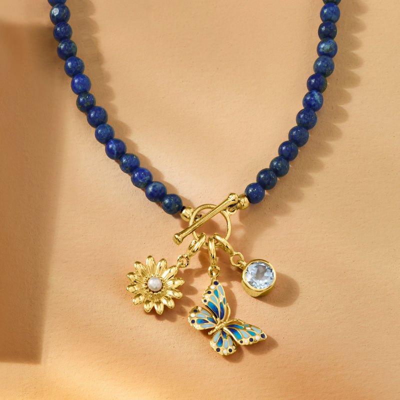Gold butterfly enamel charm with blue bead necklace and small flower and stone charms