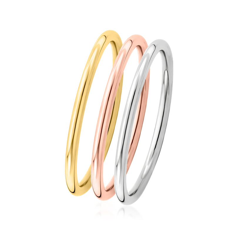 Three stackable gold rings with polished yellow, rose, and silver bands