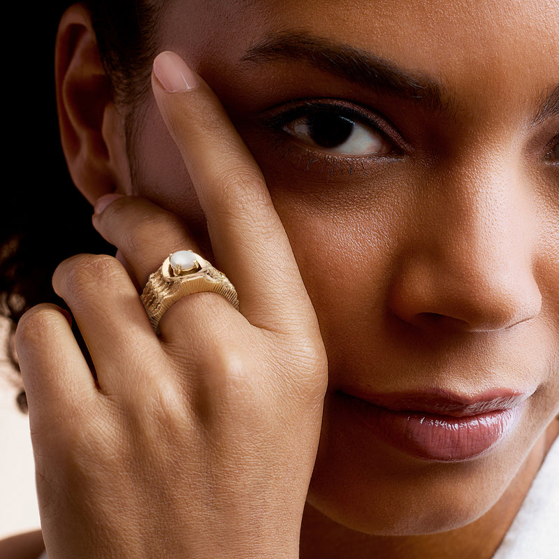 14kt yellow gold opal ring on finger with round cabochon, close-up