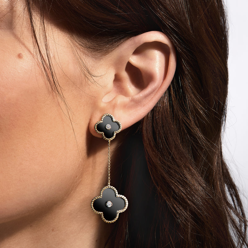 Clover drop earrings on ear: black onyx clover with diamond center, yellow gold