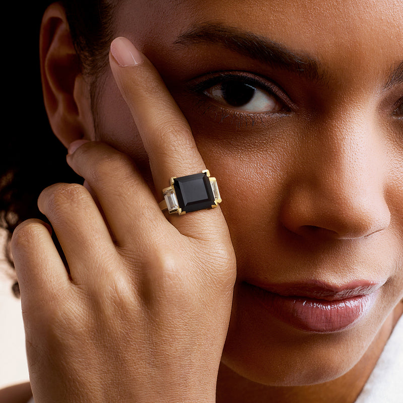 Gold over sterling onyx and topaz ring on hand, square black center with baguette sides