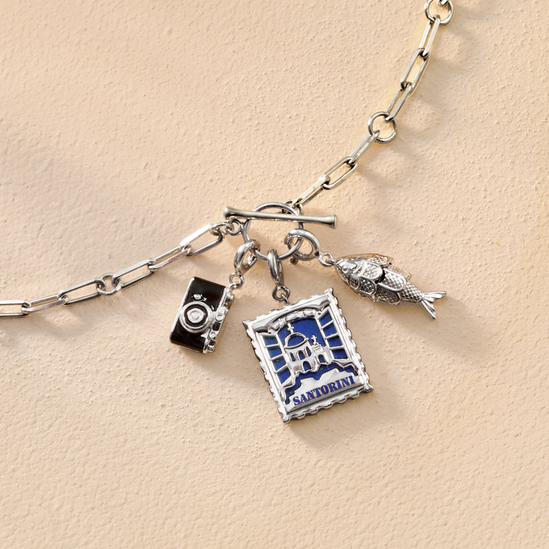 Sterling silver charm set with Santorini stamp, camera charm, and bird accent