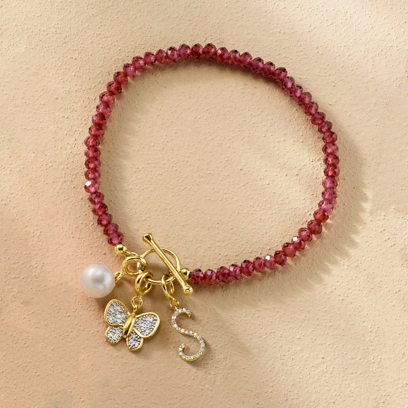 Red beaded bracelet with a gold butterfly diamond charm and small pearl detail