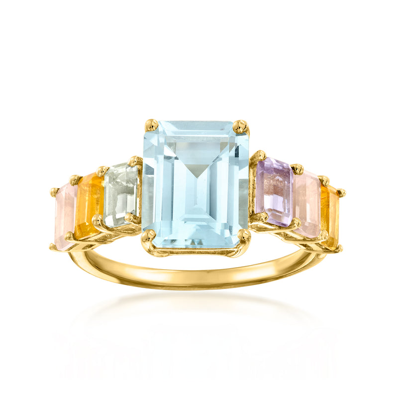 Gold-tone ring with large light blue gemstone and multicolor side stones