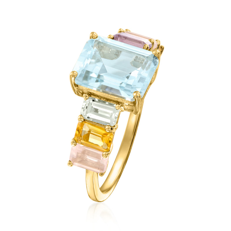 Gold-tone gemstone ring with square light blue center and orange-pink side stones