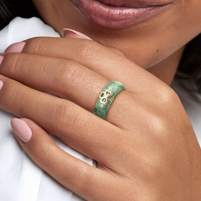 Jade green ring with four-leaf clover gold-tone motif, worn on finger