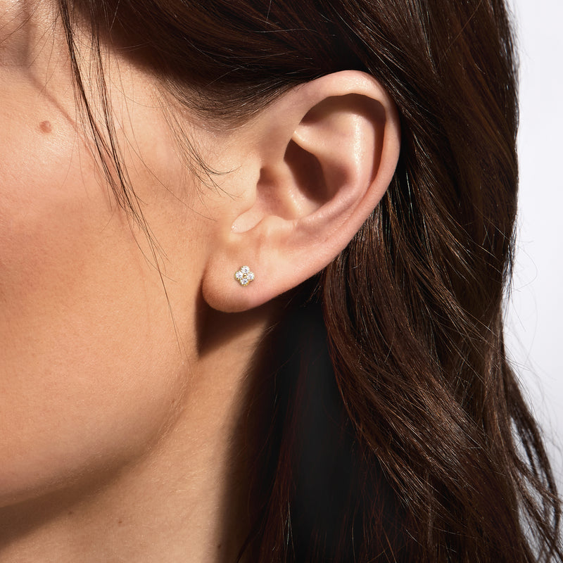 Clover diamond stud earrings on ear with four small round stones and post backing
