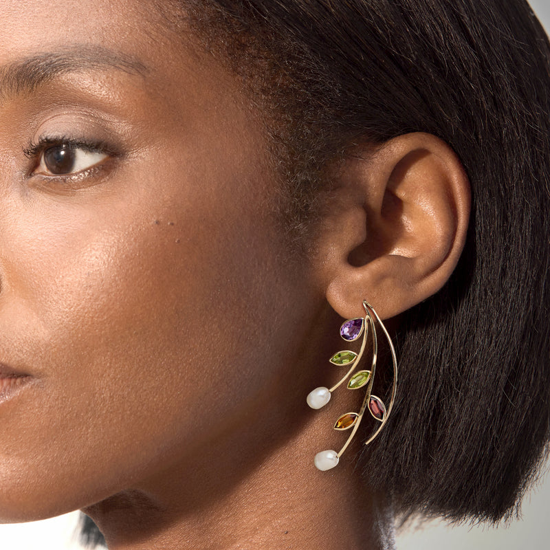 Gold vine earwire earrings with purple teardrop stones, green leaves, and cultured pearl accents