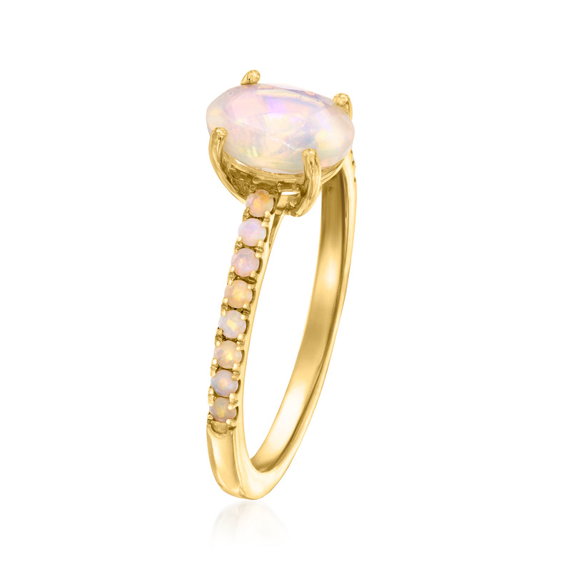 Opal birthstone ring with oval opal, gold-tone band, and pink gemstone accents