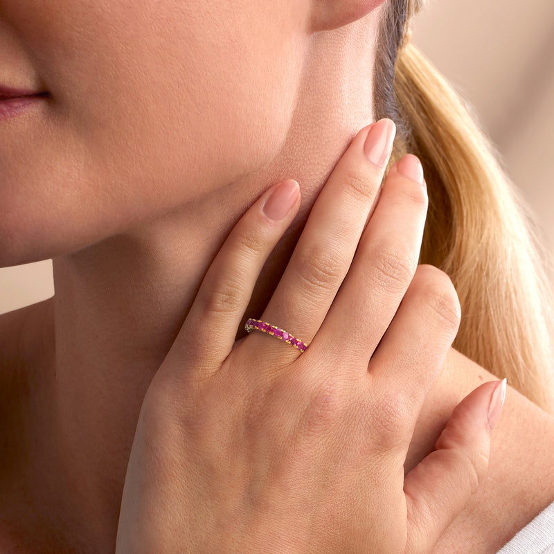 Ruby eternity band ring on hand, gold over sterling with faceted pink-red stones