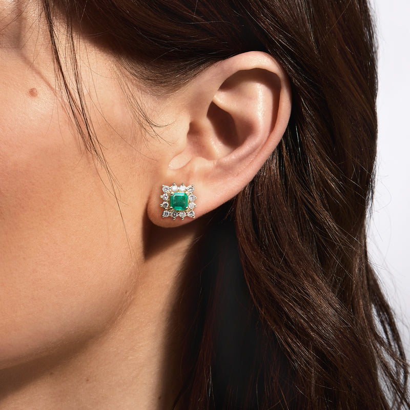 Square halo diamond and green gemstone post earrings shown on ear