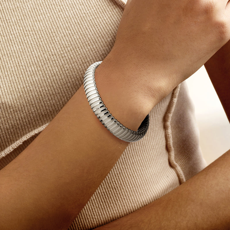 Rhodium-plated tubogas cuff bracelet on wrist, ribbed metal cuff with clasp